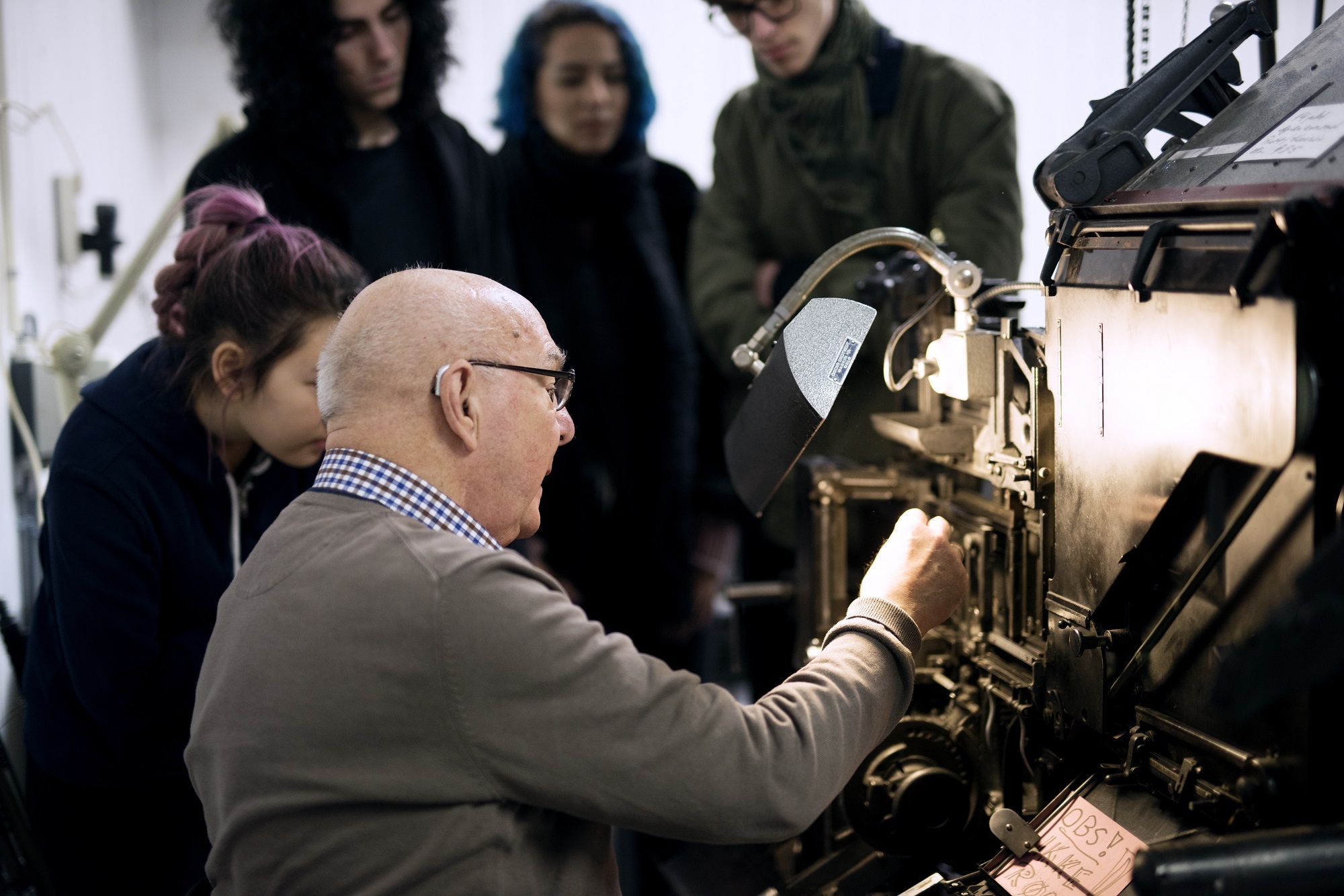 Frivillig Karl Johan Hope demonstrerer hvordan Linotype-settemaskinen fungerer